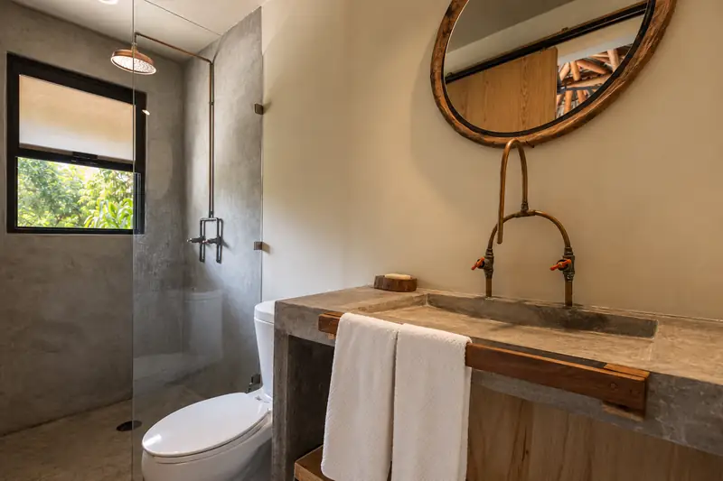 Baño con lavabo de concreto en raíz